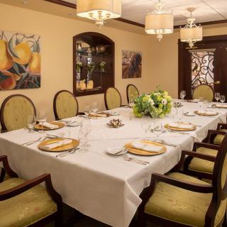 An elegantly set dining room with a large table, neatly arranged chairs, and tasteful decorations.