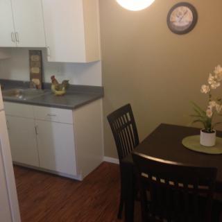 A cozy kitchen and dining area with a table, chairs, and decorative elements.
