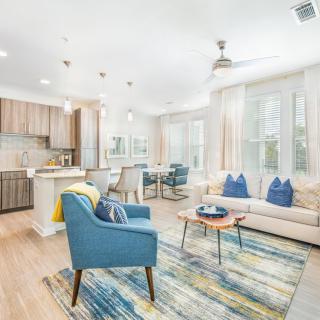 A modern and bright open-concept living space with elegant furnishings and blue accent pieces.