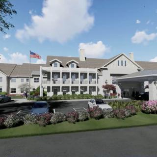 A large, elegant building with a garden and an American flag in front.