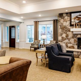 A cozy living room with modern furniture and a stone fireplace.