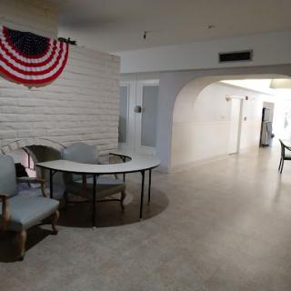 A spacious interior room featuring a table and chairs, decorated with an American flag.