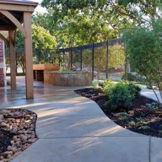 A beautifully landscaped garden with a paved walkway and lush greenery.