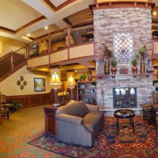 A cozy hotel lobby featuring a stone fireplace and comfortable seating.