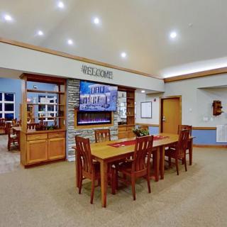 A cozy dining area with wooden furniture, a fireplace, and a mounted television.