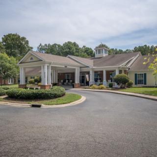 A residential building with a driveway and landscaped surroundings.