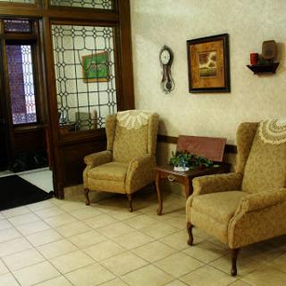 A cozy waiting area featuring two upholstered chairs and decorative elements.