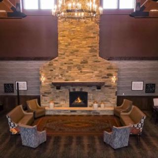 A cozy lounge area with a central stone fireplace and comfortable seating.