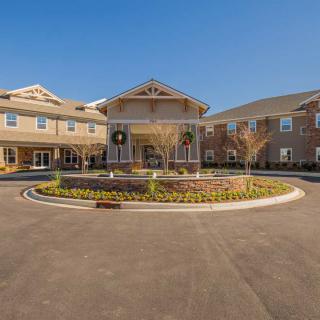 A well-maintained residential building with a circular driveway and landscaped entrance.