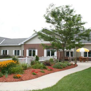 A scenic view of a house with a well-maintained garden and pathway.