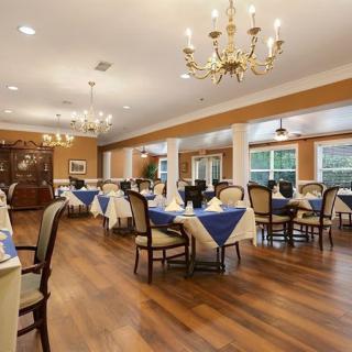 An elegantly decorated dining area with chandeliers and blue tablecloths.