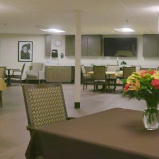 A welcoming dining area featuring elegant furniture and a vibrant flower arrangement.
