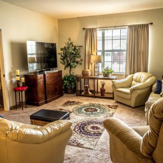 A cozy living room with leather chairs, a television, and a decorative rug.
