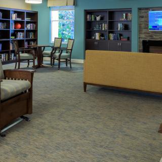 A cozy library interior with seating and bookshelves.
