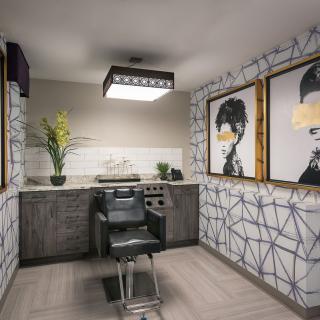 A modern hair salon interior with stylish artwork and a comfortable barber chair.