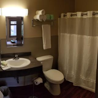 A well-organized bathroom featuring a shower, toilet, and sink.