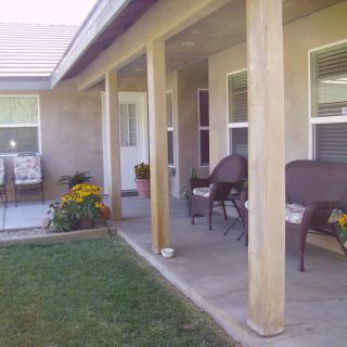 A cozy patio area with chairs and a garden in the backyard.
