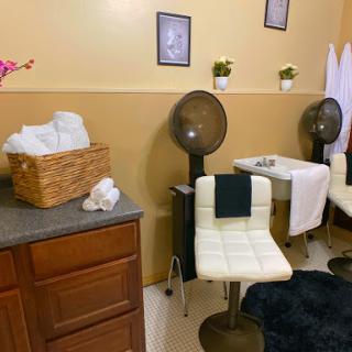 A cozy salon space designed for hair and beauty treatments, featuring comfortable seating and a warm atmosphere.