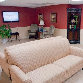 A cozy living room setup featuring a light-colored sofa, a television, and comfortable seating options.