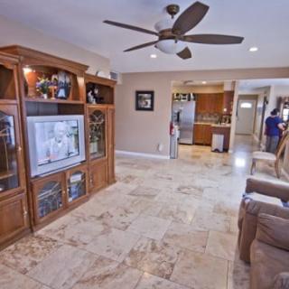 A cozy living room with an entertainment center and a view into the kitchen.