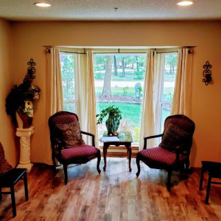 Cozy living room area with chairs and a window overlooking a garden.