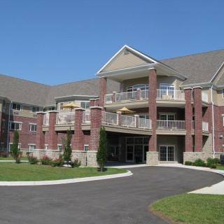 A modern residential apartment building with a landscaped driveway.