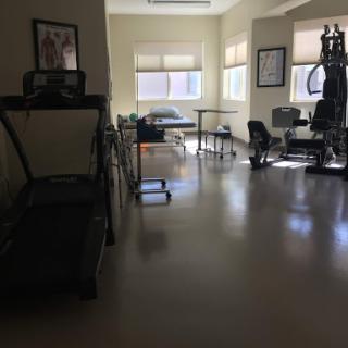 A view of a rehabilitation therapy room equipped with exercise machines and seating.