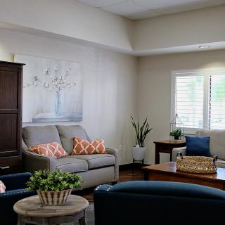 A cozy living room with a sofa, armchairs, and decorative elements.