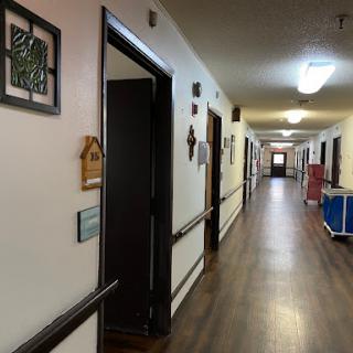 A well-lit corridor featuring various doors and wall decorations.