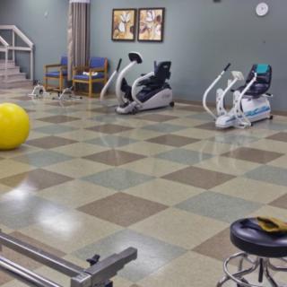 A gym with various exercise equipment, including stationary bikes and a large exercise ball.
