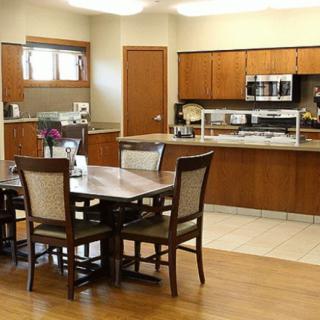 A modern kitchen with wooden cabinetry and a dining area.