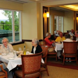People dining in a restaurant with large windows and elegant interior.