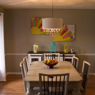 A modern dining room with a central table, surrounded by chairs and adorned with contemporary artwork and decor.