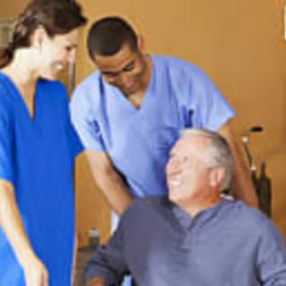 Healthcare professionals assisting a patient in a wheelchair.