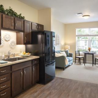A modern apartment with an open floor plan featuring a kitchen and living room area.