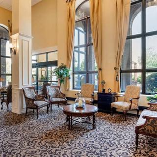 Elegant hotel lobby with classic furniture and large windows.