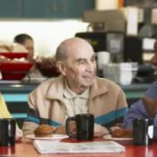 A group of people enjoying a conversation over breakfast in a cafe.