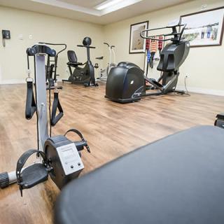 A gym with various fitness machines and equipment.