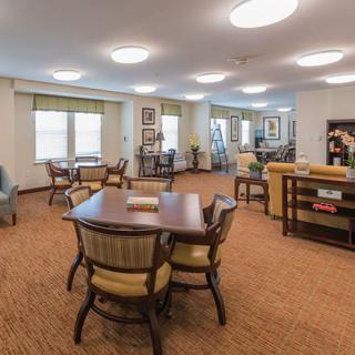 A well-lit and spacious living area with multiple tables and chairs.