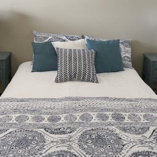 A neatly made bed with decorative pillows and patterned bedding.