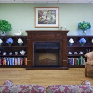 Cozy living room with a fireplace, decorated shelves, and comfortable seating.