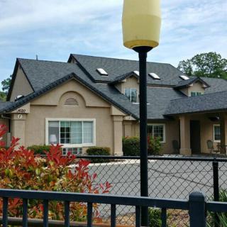 A suburban house with a fenced yard and landscaped surroundings.