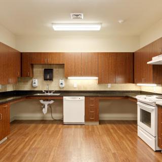 A modern kitchen featuring wooden cabinets, sleek countertops, and essential appliances.