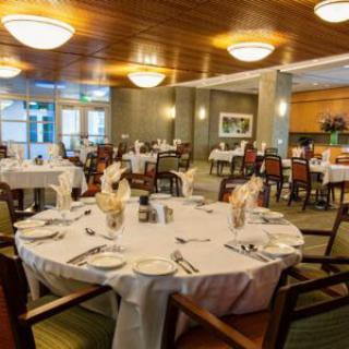 An elegant dining room with well-set tables and warm lighting.