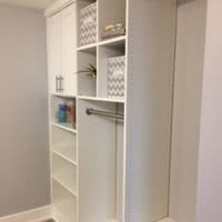 A neatly organized white closet with shelves and hanging space.