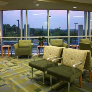 A modern waiting room with comfortable chairs and large windows.