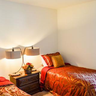 A cozy bedroom with two twin beds and a shared nightstand.