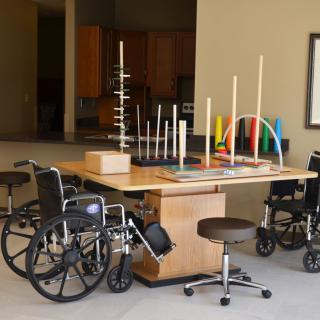 Therapy room equipped with wheelchairs and various physical therapy tools.