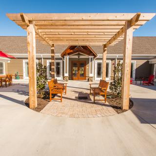 A beautifully designed outdoor patio area with a wooden pergola and seating.