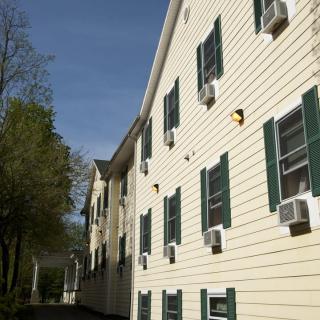 A residential building with multiple windows and air conditioning units under a clear blue sky.